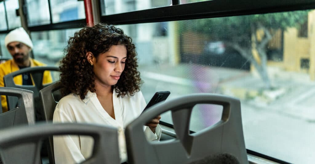 Young Woman Using Mobile Phone On Bus (1)